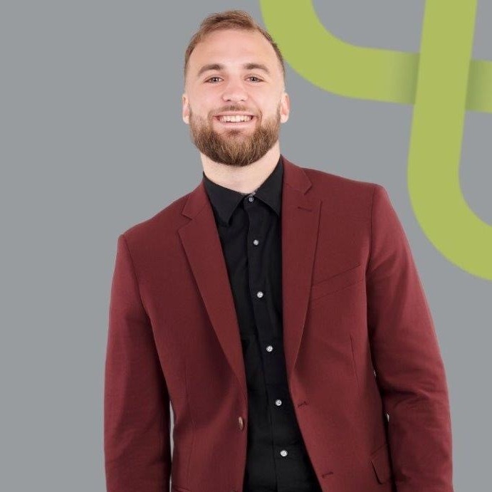 Man smiling in burgundy suit