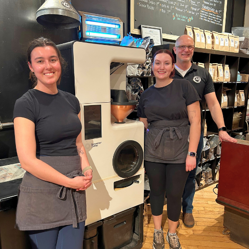 A group of people standing together inside a coffee shop