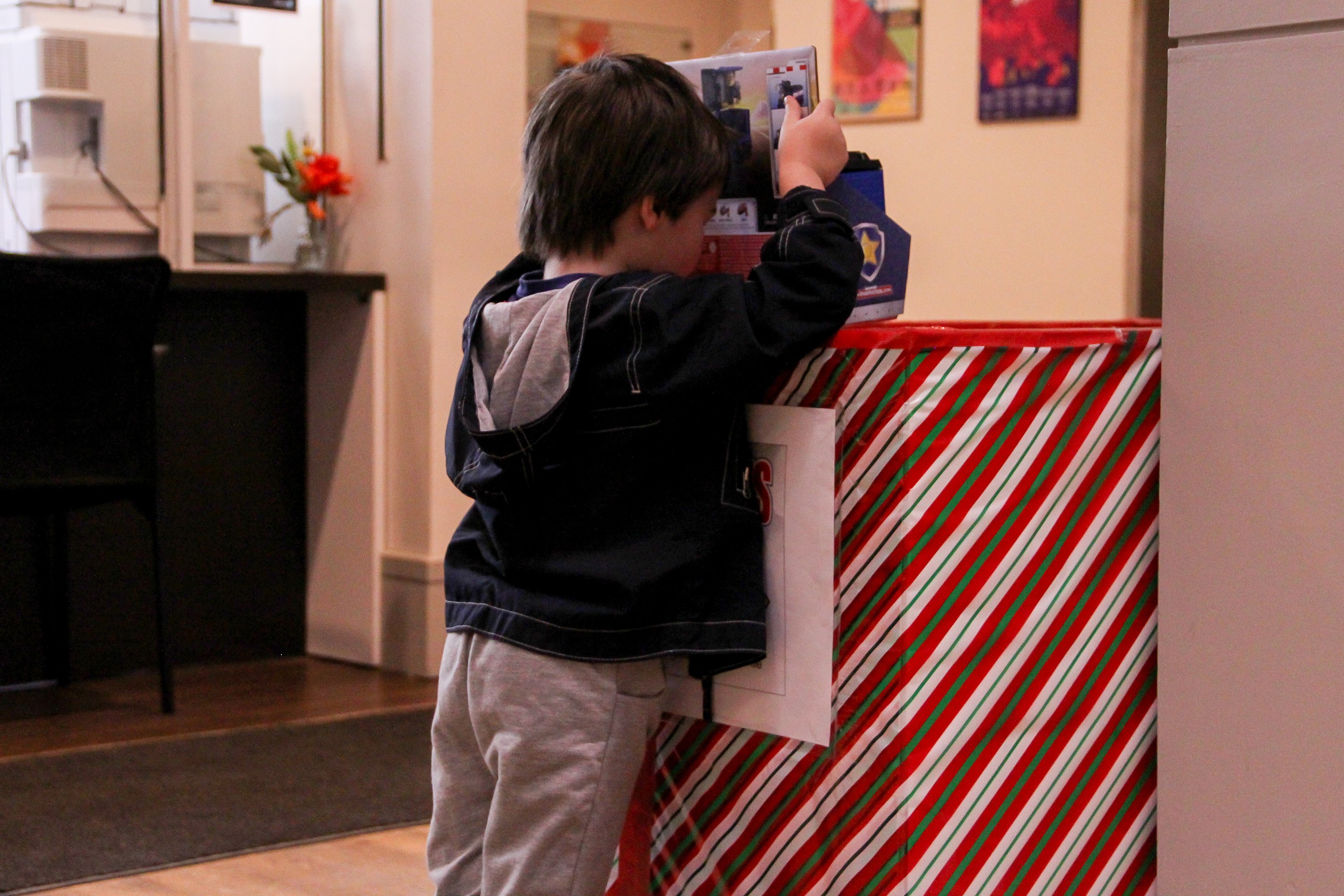 A child drops a toy donation in a Toys for Tots collection box
