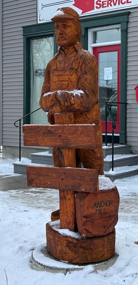 A wood carved statue of a farmer