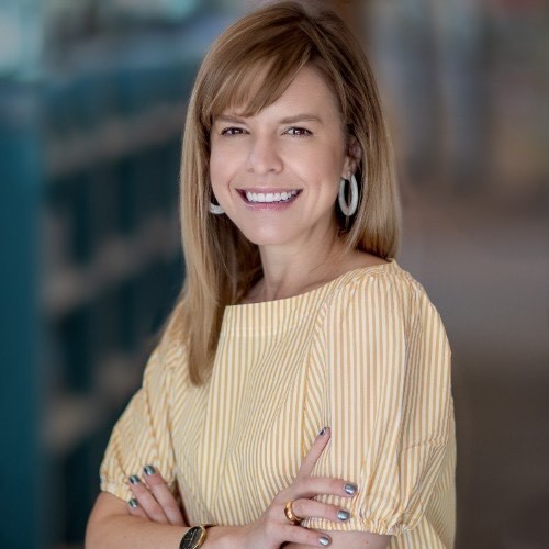 A photo of a person smiling with their arms crossed. Headshot of Laura Warner, the new CEO of the Orangeville Public Library.