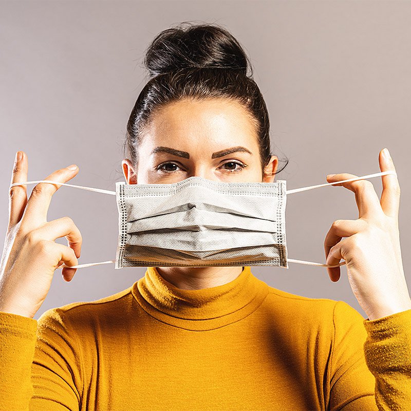 woman putting on a mask