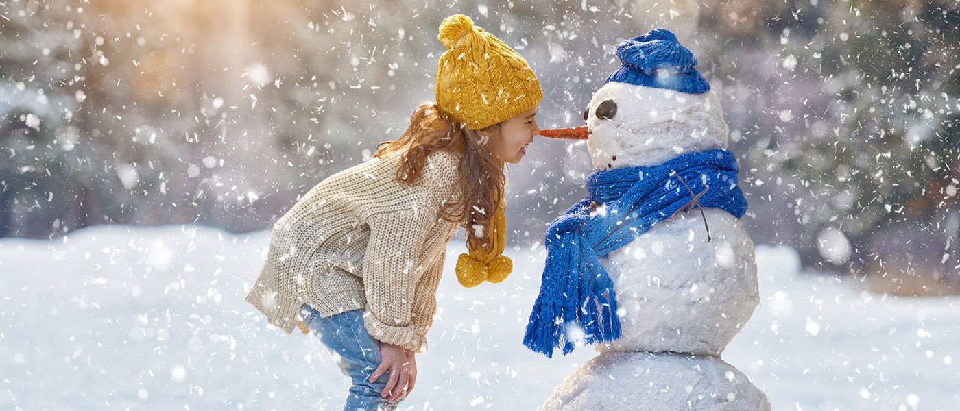 little girl nose to nose with a snowman