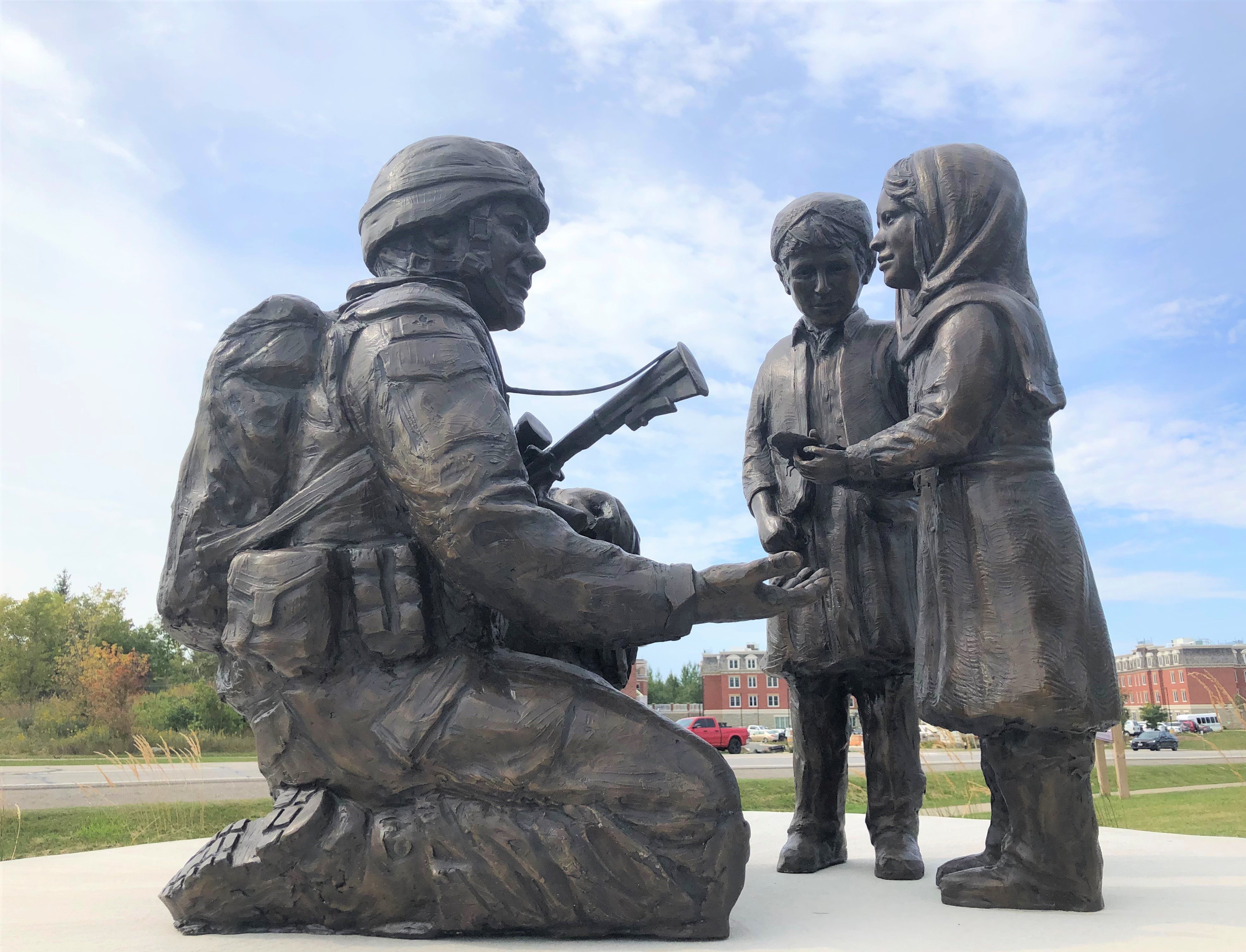 Bronze statue of solider kneeling in front of two children