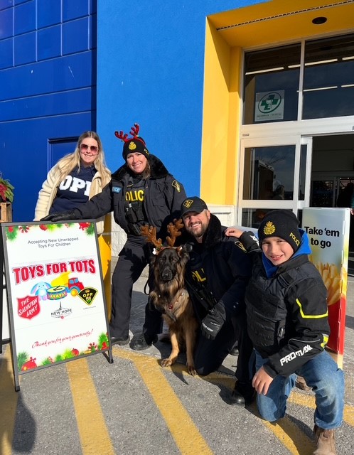 A group of police officers and some residents stand outside a Walmart for a toy drive
