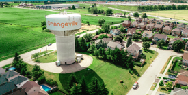 An aerial shot of a subdivision and a water reservoir. 