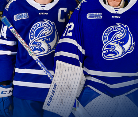 Two Brampton Steelheads hockey players stand in uniform next to eachother