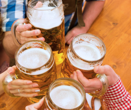 Four people clinking beer glasses together