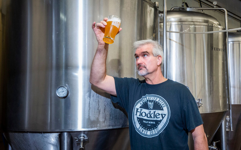 Man holding up a glass of beer