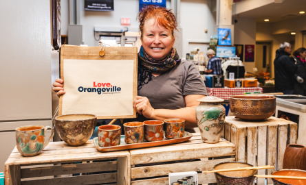 Woman sitting on street bench looking at her phone