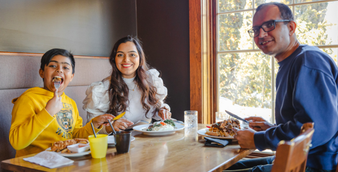 A mother, father and son sit in a booth enjoying lunch