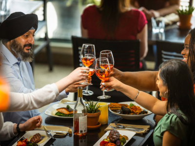 A groups holds up their wine glasses to cheers.