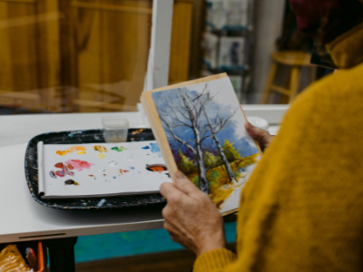 Artist holding a painting with a palette