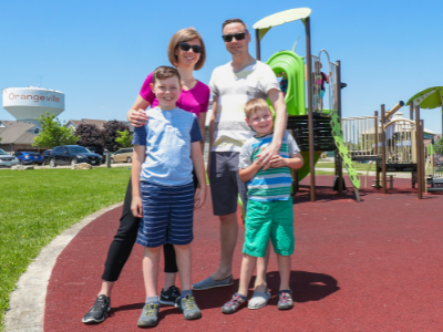 A family poses for a photo in a park.